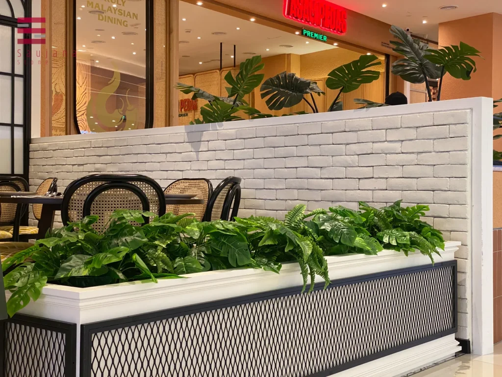 Classic Brick in whitewash finish used on indoor partition wall – clean backdrop for tropical-themed planter display